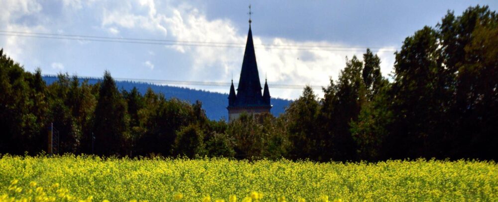 Der Turm der Schwarzenbacher Kirche schiebt sich markant in die oberfränkische Landschaft